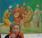 Fotografia che ritrae Alice Psacaropulo con alle spalle un suo dipinto