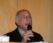 Gillo Dorfles con microfono durante una conferenza